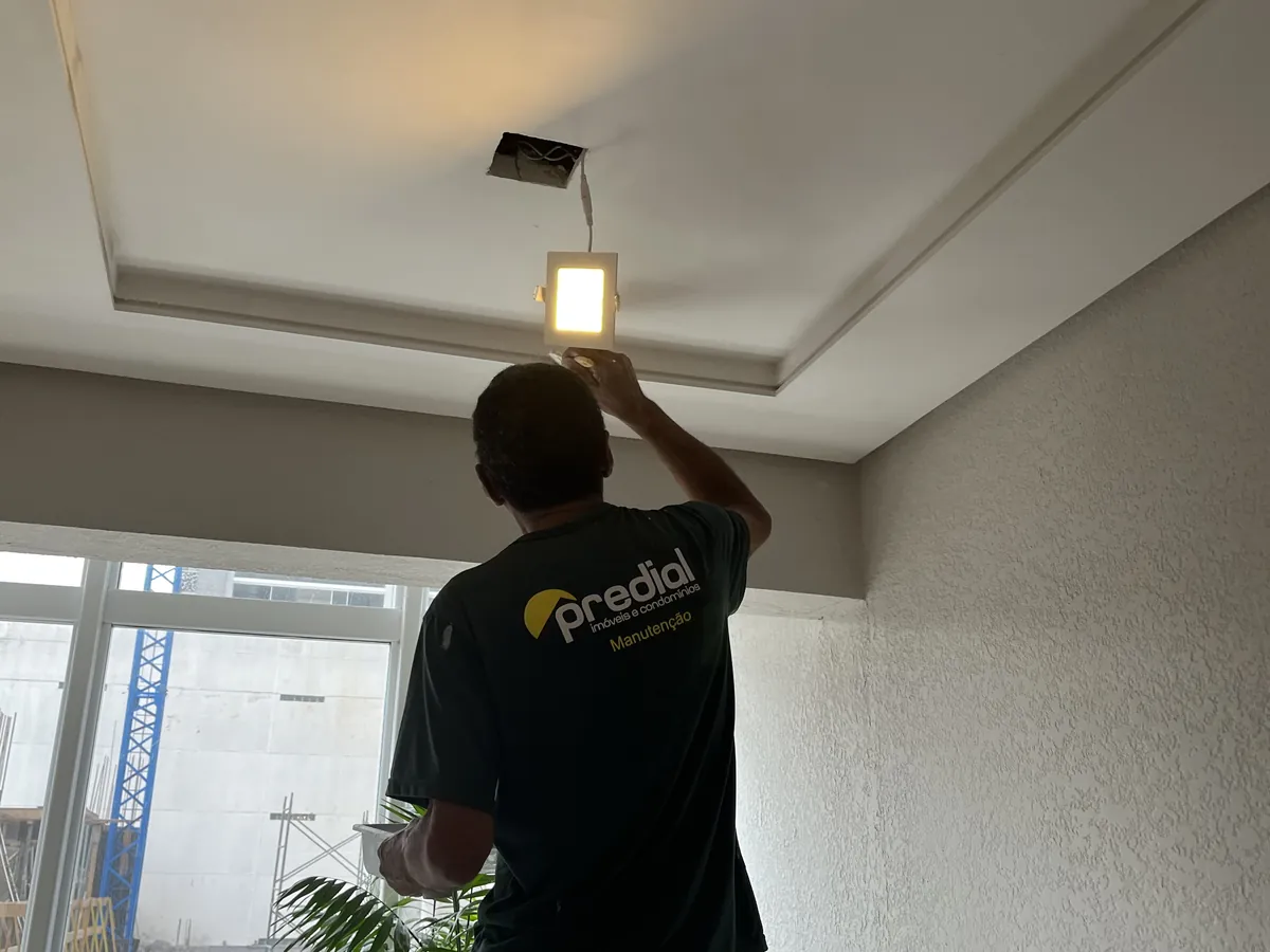 Colaborador do Grupo Predial pintando o acabamento do teto de um ambiente interno